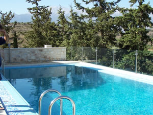 Infinity style swimming pool with reinforced glass protective barrier