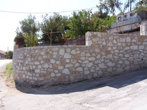 Curved and stepped stone boundary wall.
