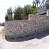 Curved and stepped stone boundary wall.