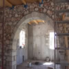Internal arch with exposed ceiling beams and stonework detail.