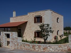 Stone villa with boundary wall and covered patio.